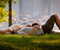 Romantic Couple Laying On Grass Out Of City