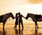 Romantický pár na pláži s koňom